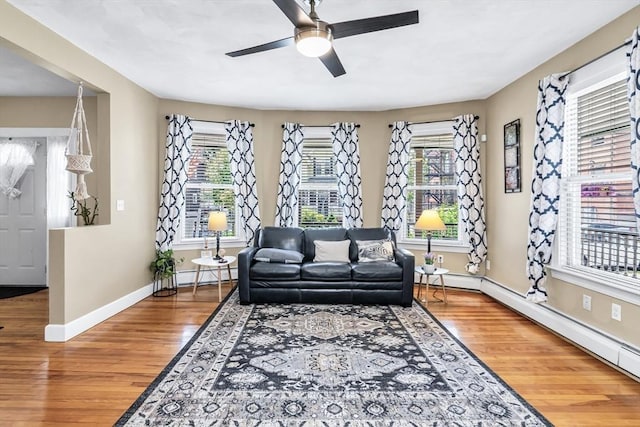 16 Pacific St, Lynn, MA 01902 - living area with wood finished floors, plenty of natural light, ceiling fan, and a baseboard heating unit