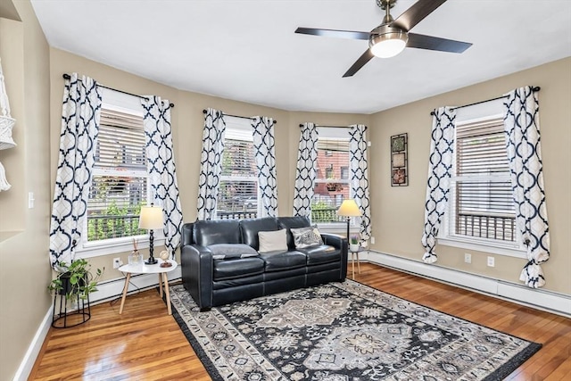 16 Pacific St, Lynn, MA 01902 - living room featuring light wood-style flooring, a baseboard heating unit, a ceiling fan, and baseboard heating