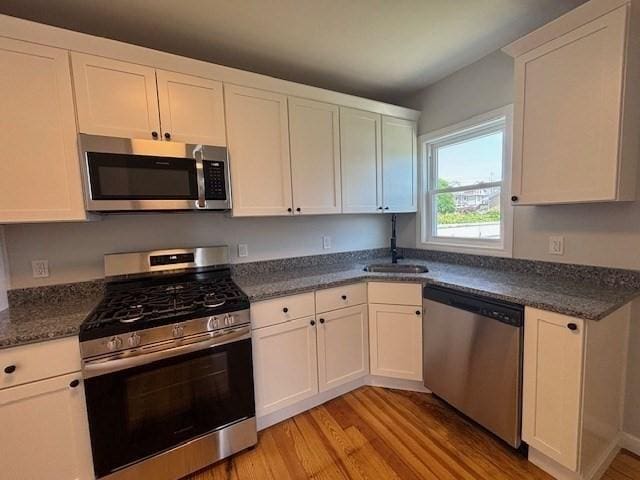 404 Brayton Ave, Fall River, MA 02721 - kitchen featuring stainless steel appliances, light wood finished floors, and white cabinetry