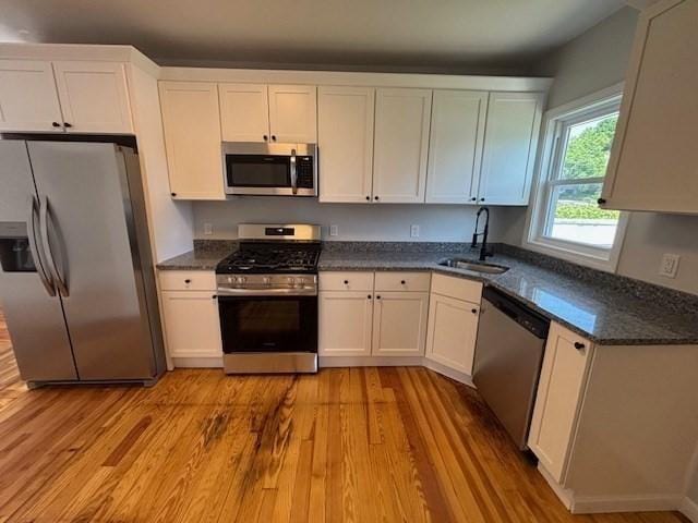 404 Brayton Ave, Fall River, MA 02721 - kitchen with stainless steel appliances, light wood-type flooring, white cabinets, and dark stone countertops