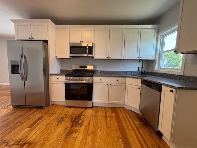 404 Brayton Ave, Fall River, MA 02721 - kitchen featuring appliances with stainless steel finishes, light wood-style floors, and white cabinetry
