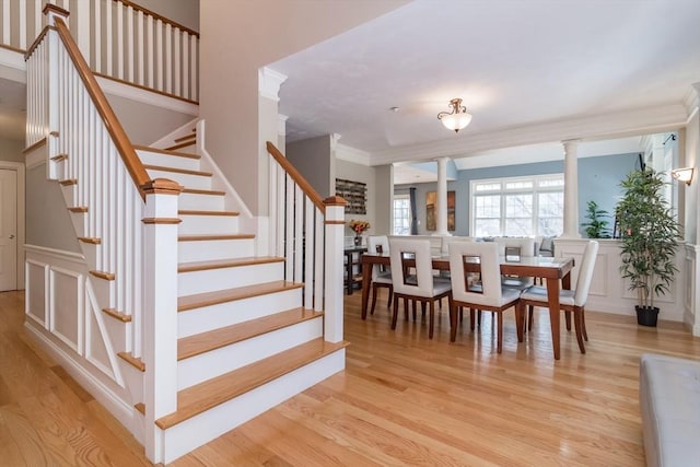 interior space with crown molding, hardwood / wood-style flooring, and ornate columns