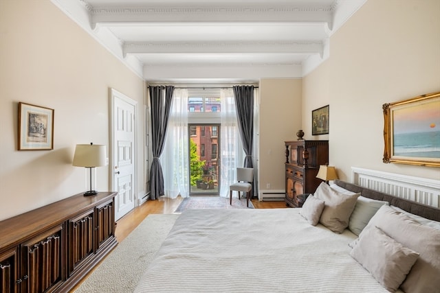 bedroom with beamed ceiling, light hardwood / wood-style floors, and baseboard heating