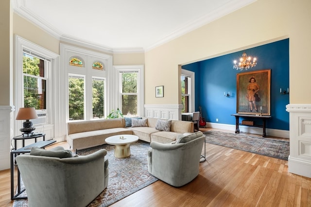 living room with a notable chandelier, crown molding, hardwood / wood-style floors, and a wealth of natural light