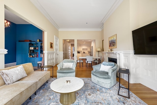 living room with crown molding, hardwood / wood-style floors, and built in features