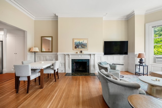 living room featuring light hardwood / wood-style floors, cooling unit, a fireplace, and ornamental molding