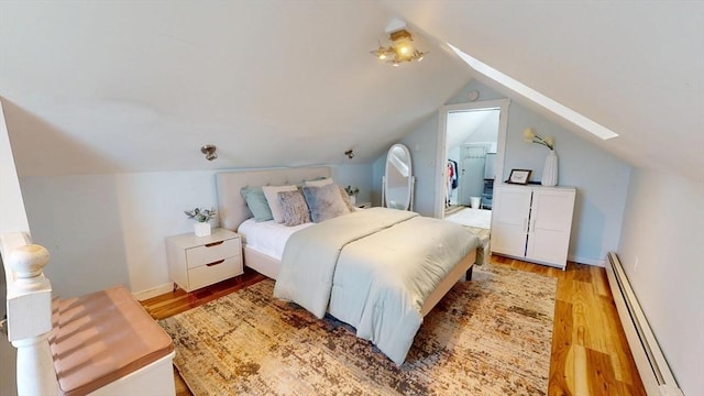 31-33 Harvard St, Medford, MA 02155 - bedroom featuring a baseboard heating unit, lofted ceiling, light wood-style flooring, and a spacious closet