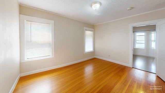 31-33 Harvard St, Medford, MA 02155 - unfurnished room with light wood-style flooring, crown molding, a textured ceiling, and a smoke detector