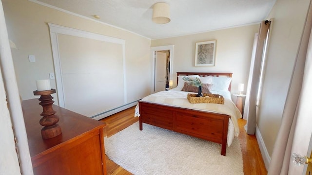 31-33 Harvard St, Medford, MA 02155 - bedroom with light wood-type flooring, crown molding, and a baseboard heating unit