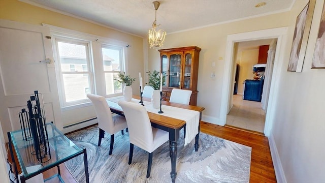 31-33 Harvard St, Medford, MA 02155 - dining space featuring light wood-style floors, a chandelier, ornamental molding, and baseboard heating