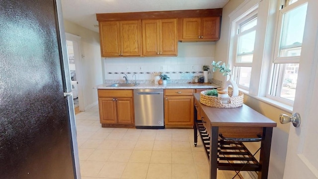 31-33 Harvard St, Medford, MA 02155 - kitchen featuring stainless steel dishwasher, freestanding refrigerator, backsplash, light countertops, and brown cabinets
