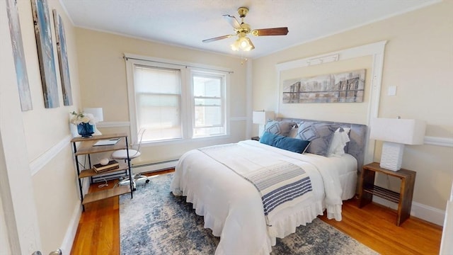 31-33 Harvard St, Medford, MA 02155 - bedroom with wood finished floors, a baseboard heating unit, and ceiling fan