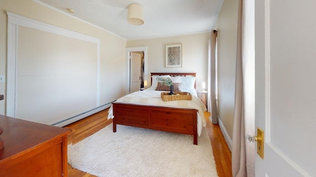 31-33 Harvard St, Medford, MA 02155 - bedroom with a baseboard radiator, crown molding, and light wood finished floors