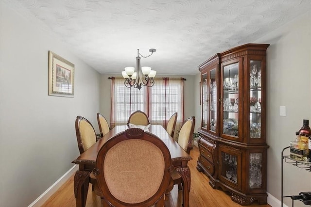 544 Main St, Stoneham, MA 02180 - dining space featuring a chandelier, light wood-style flooring, baseboards, and a textured ceiling
