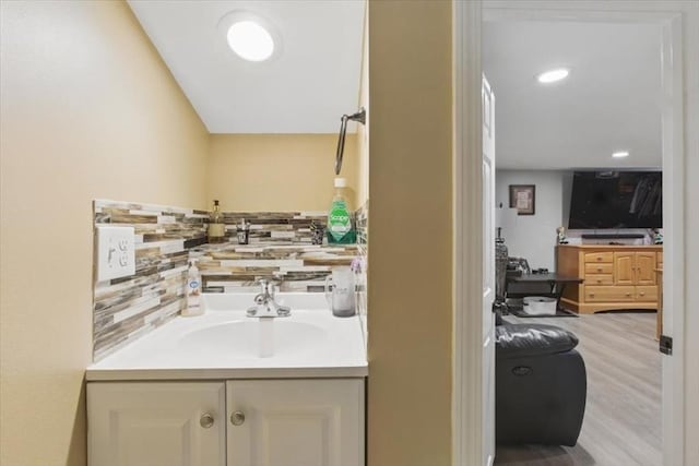 544 Main St, Stoneham, MA 02180 - bathroom featuring vanity, wood finished floors, and tasteful backsplash