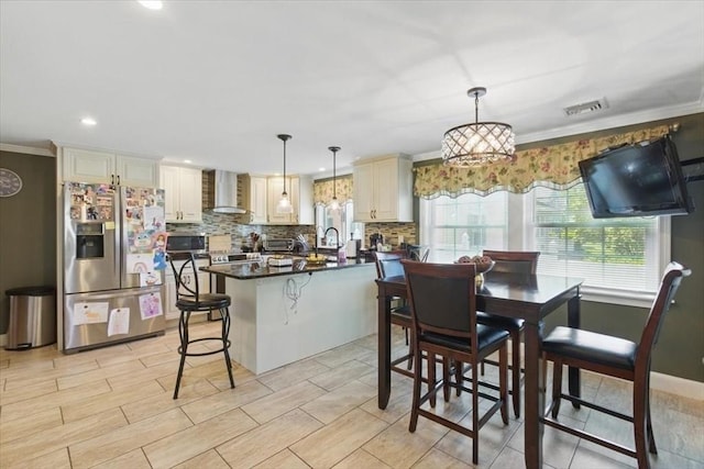 544 Main St, Stoneham, MA 02180 - kitchen with appliances with stainless steel finishes, wall chimney range hood, decorative backsplash, dark countertops, and ornamental molding