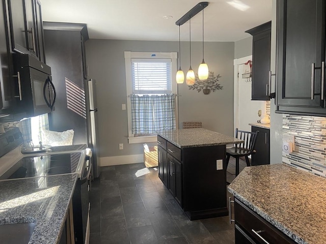 kitchen featuring electric range, dark stone countertops, dark cabinets, freestanding refrigerator, and backsplash