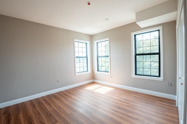 empty room featuring hardwood / wood-style flooring and a healthy amount of sunlight