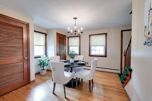143 Elizabeth, Westfield, MA 01085 - dining area with a chandelier, healthy amount of natural light, light wood-style floors, a baseboard radiator, and a textured ceiling
