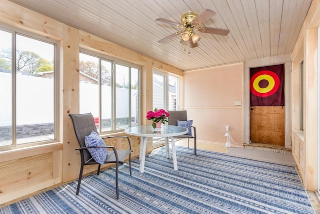 sunroom with a ceiling fan and wood ceiling