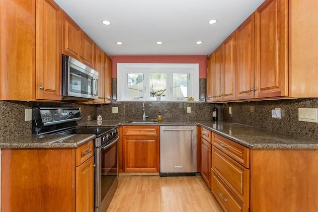 kitchen featuring brown cabinets, stainless steel appliances, and light wood-style flooring