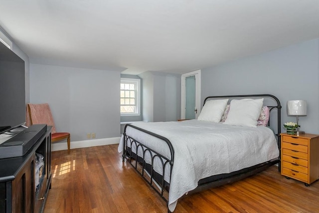 bedroom with baseboards and wood finished floors