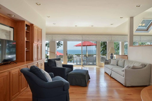 living room featuring light wood-type flooring and a water view