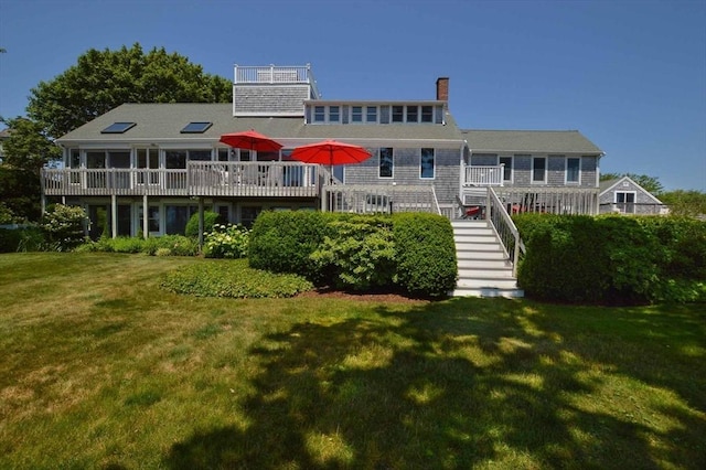 view of front facade with a front yard and a wooden deck