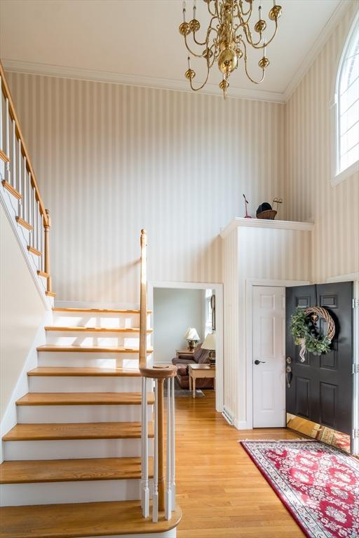 5 Warner Way, Canton, MA 02021 - entrance foyer with wallpapered walls, stairs, wood finished floors, ornamental molding, and a chandelier
