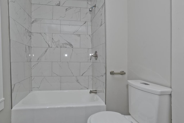 bathroom with toilet and tiled shower / bath combo