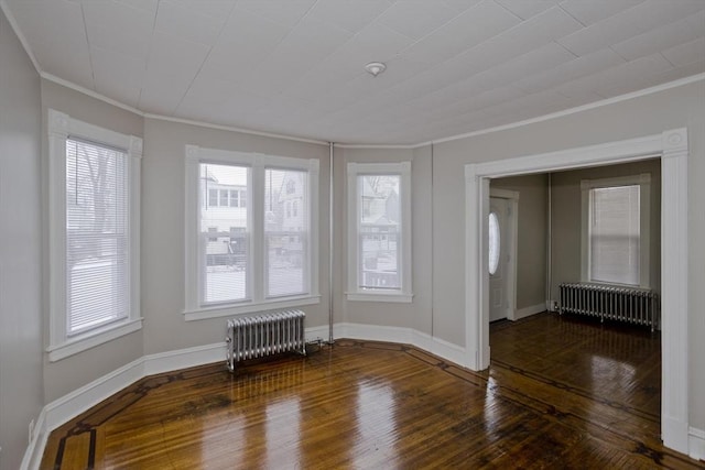 unfurnished room featuring crown molding, radiator, and hardwood / wood-style floors