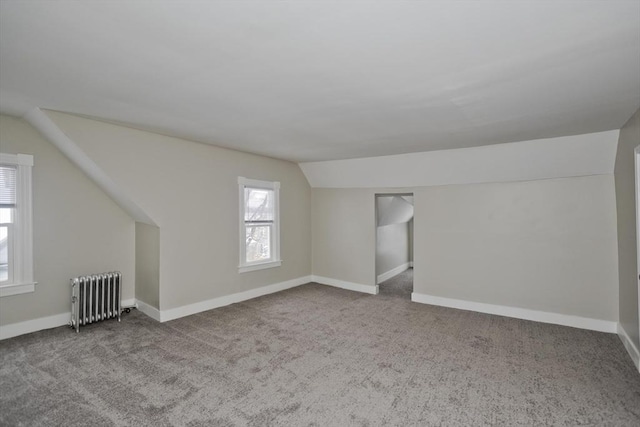 additional living space featuring lofted ceiling, radiator heating unit, and carpet flooring