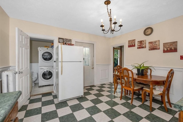 89 Merrill Ave, Lowell, MA 01850 - dining space featuring stacked washing machine and dryer, a wainscoted wall, a chandelier, and a decorative wall