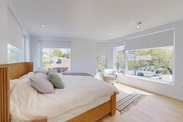 bedroom with multiple windows, light wood-style flooring, baseboards, and recessed lighting