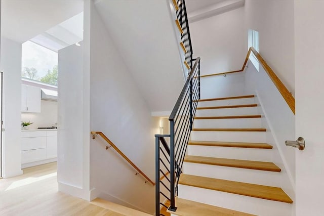stairs with wood finished floors and baseboards