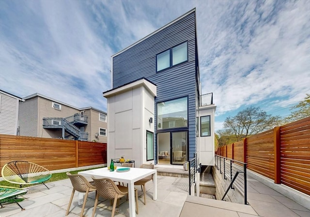 rear view of house with a patio, a fenced backyard, and outdoor dining area