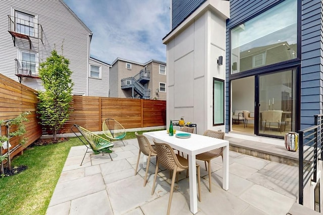 view of patio / terrace featuring outdoor dining space, a fenced backyard, and a residential view