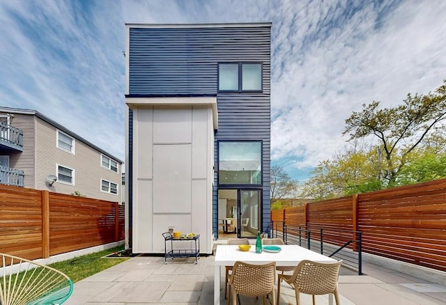 view of outdoor structure with a fenced backyard and outdoor dining space