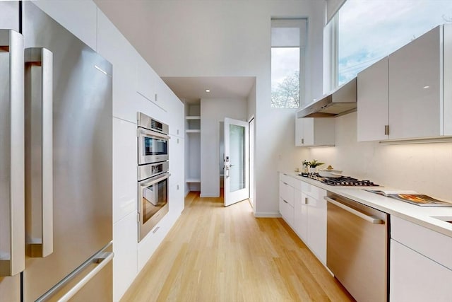 kitchen featuring appliances with stainless steel finishes, light wood-style floors, light countertops, and white cabinetry