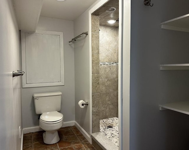 bathroom featuring toilet and tiled shower