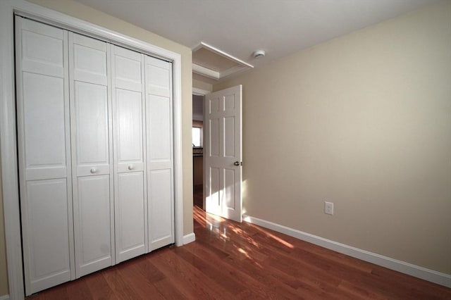 unfurnished bedroom featuring dark hardwood / wood-style flooring and a closet