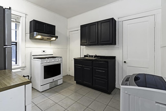 108 Washington St Unit 3, Boston, MA 02135 - kitchen with white gas range oven, under cabinet range hood, a sink, light tile patterned floors, and dark cabinetry