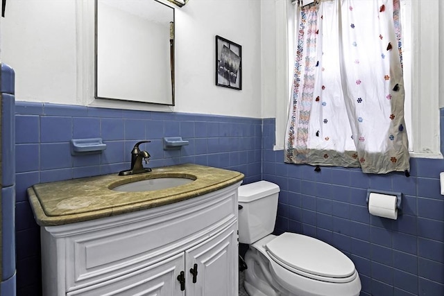 108 Washington St Unit 3, Boston, MA 02135 - bathroom with tile walls, toilet, a wainscoted wall, and vanity