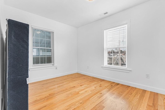 unfurnished room with hardwood / wood-style flooring