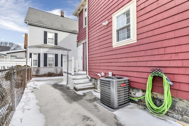 snow covered property with central AC