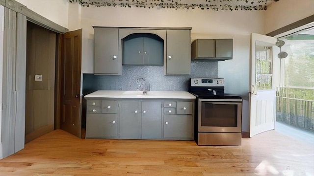 48 Summer St, Adams, MA 01220 - kitchen with stainless steel electric range, gray cabinetry, light wood finished floors, backsplash, and light countertops