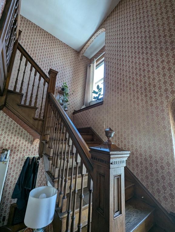 stairs featuring wallpapered walls