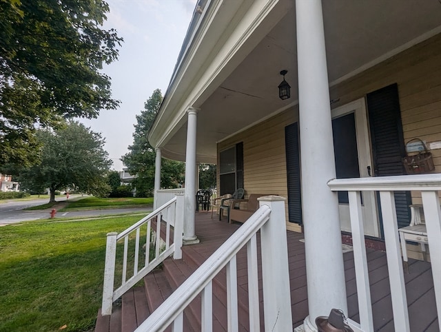 deck with a porch and a lawn