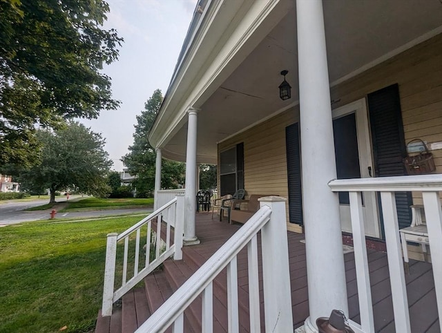 wooden terrace with covered porch and a lawn