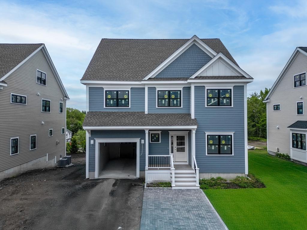 view of front of home featuring a porch, roof with shingles, asphalt driveway, a garage, and a front lawn